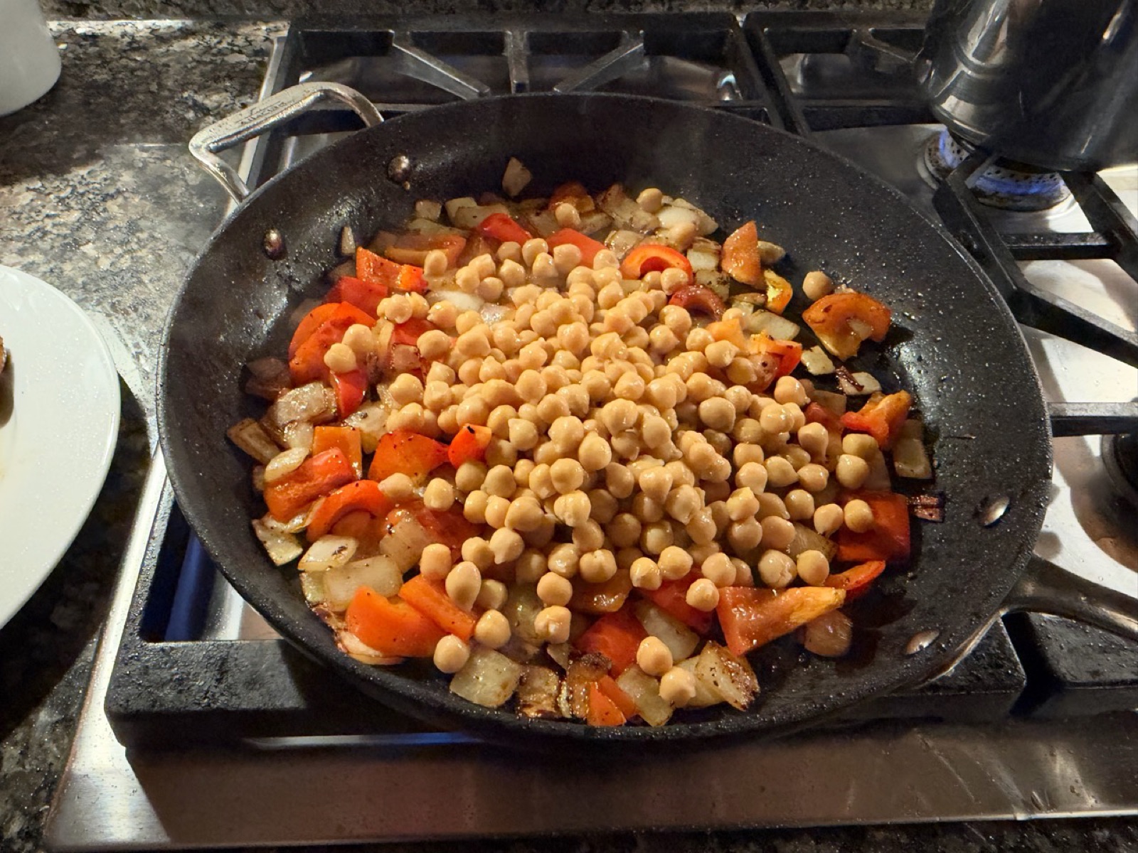 Chickpeas piled over sautéed onions and red pepper in the skillet before adding the chicken and sauce.
