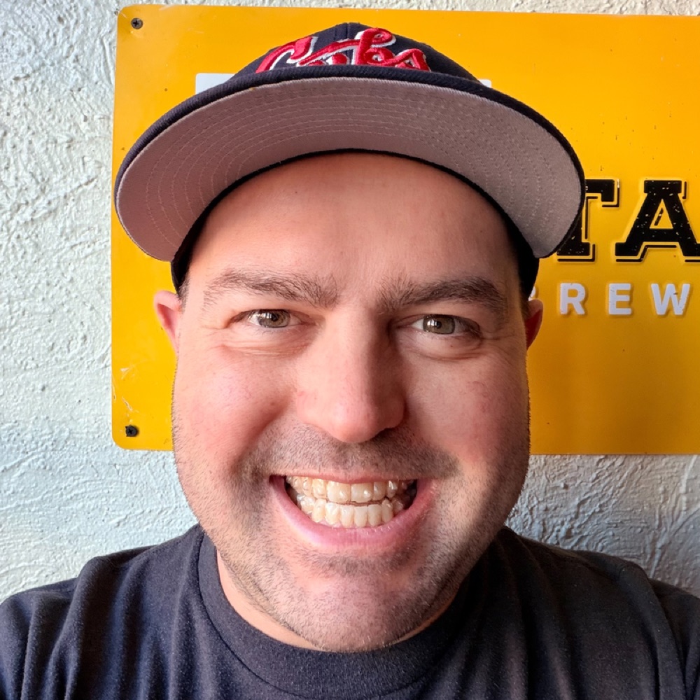 Mager smiling in a baseball cap.
